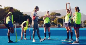 Women hockey players warming up and training on a field hockey pitch at Greensborough Hockey Club.